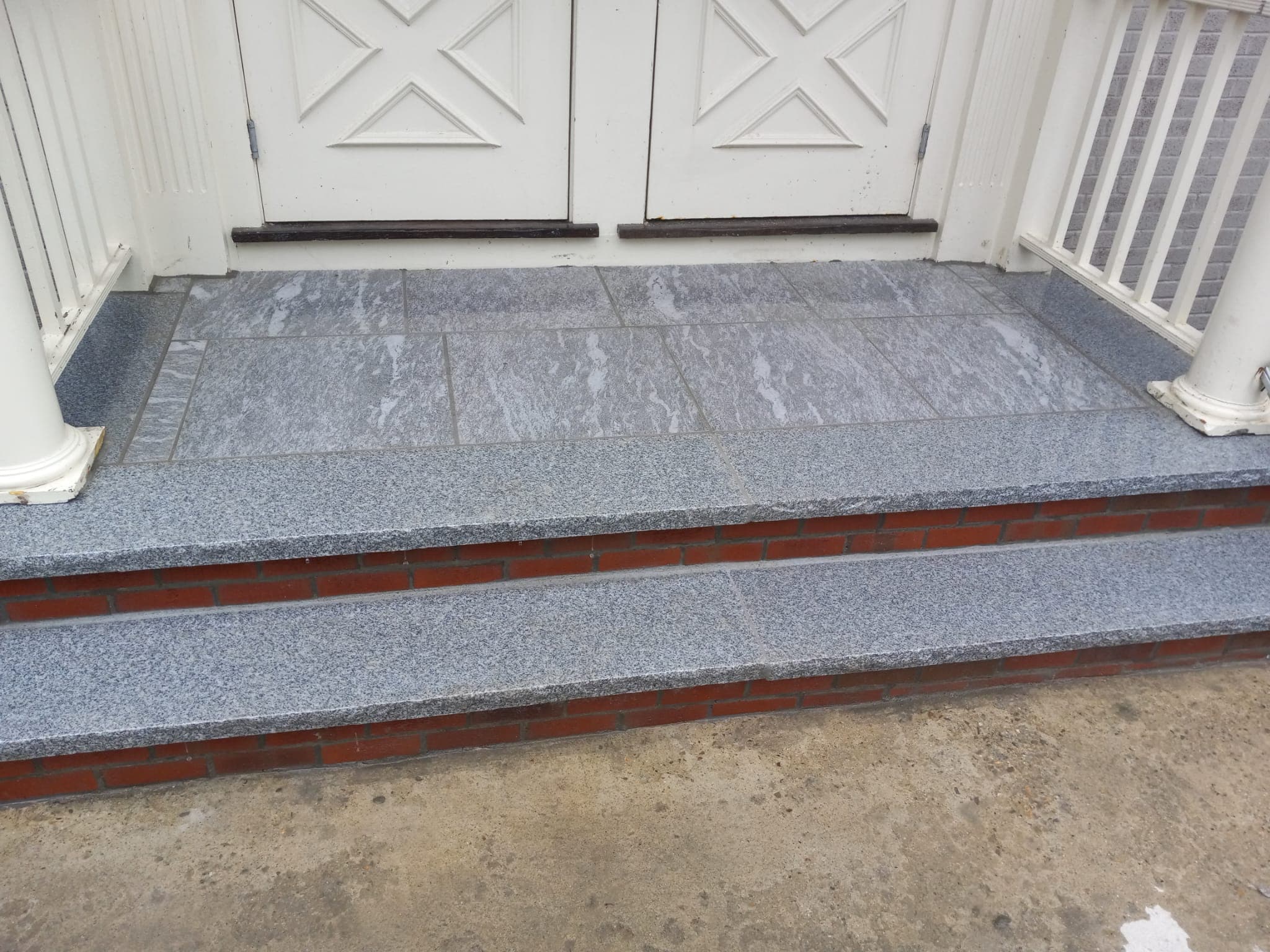 Granite-tile front stoop with brick riser detail