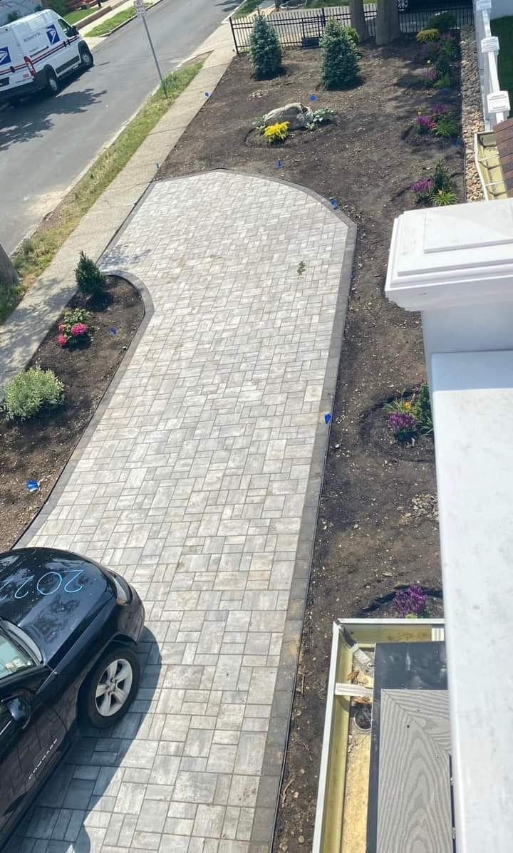 Long paver walkway with curved border and landscaped beds